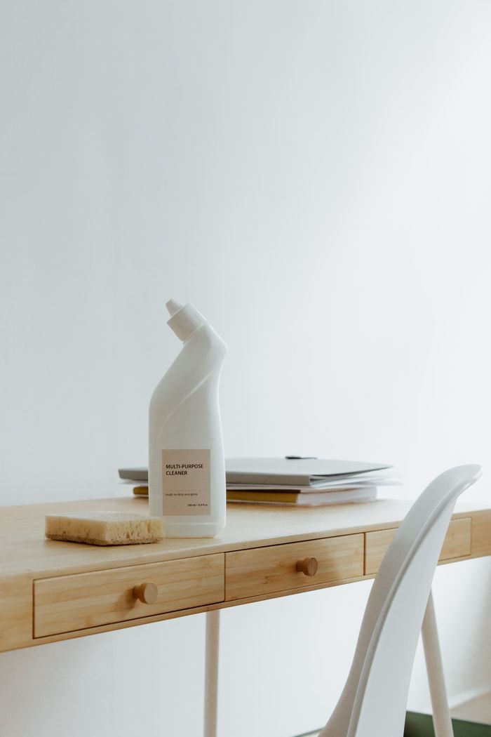 hero-img-02 A clean and organized home office desk with a cleaner bottle and sponge, emphasizing simplicity and functionality.